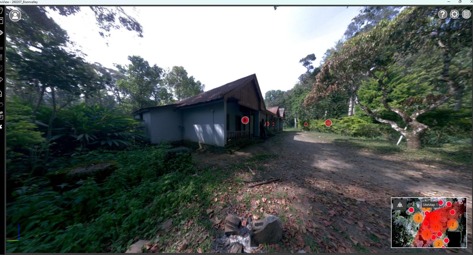On-site LiDAR scanner capturing a building within dense vegetation at Kuttikanam, Kerala, with red scan position markers visible on the structure